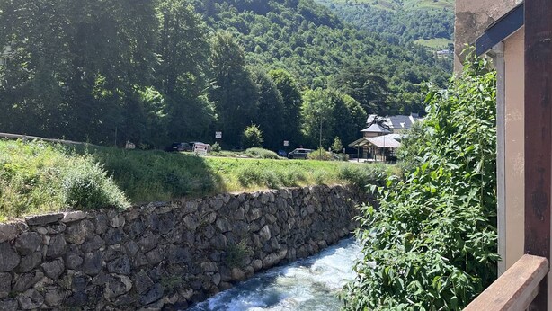 A stone wall beside a flowing river, surrounded by lush greenery and a mountainous backdrop. - Renovated, balcony, Cauterets center (Cauterets)