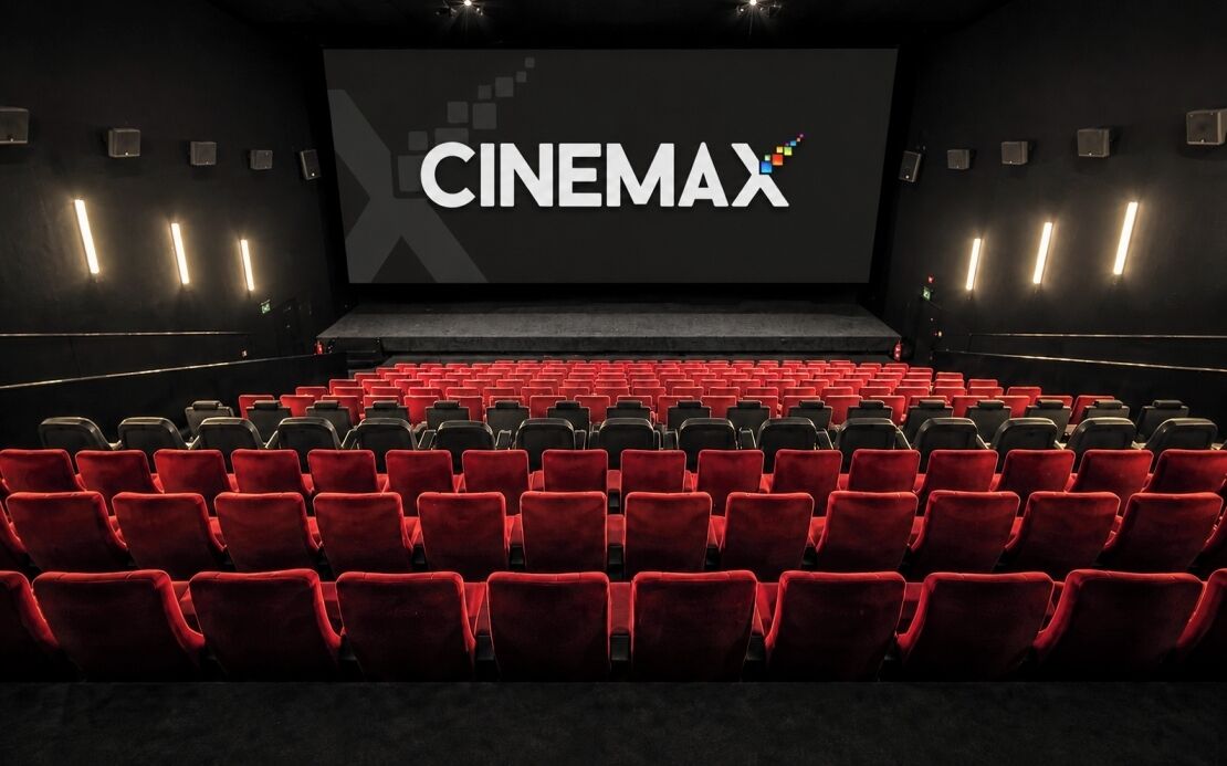 A cinema with red seats and a large screen displaying 'CINEMAX'.
