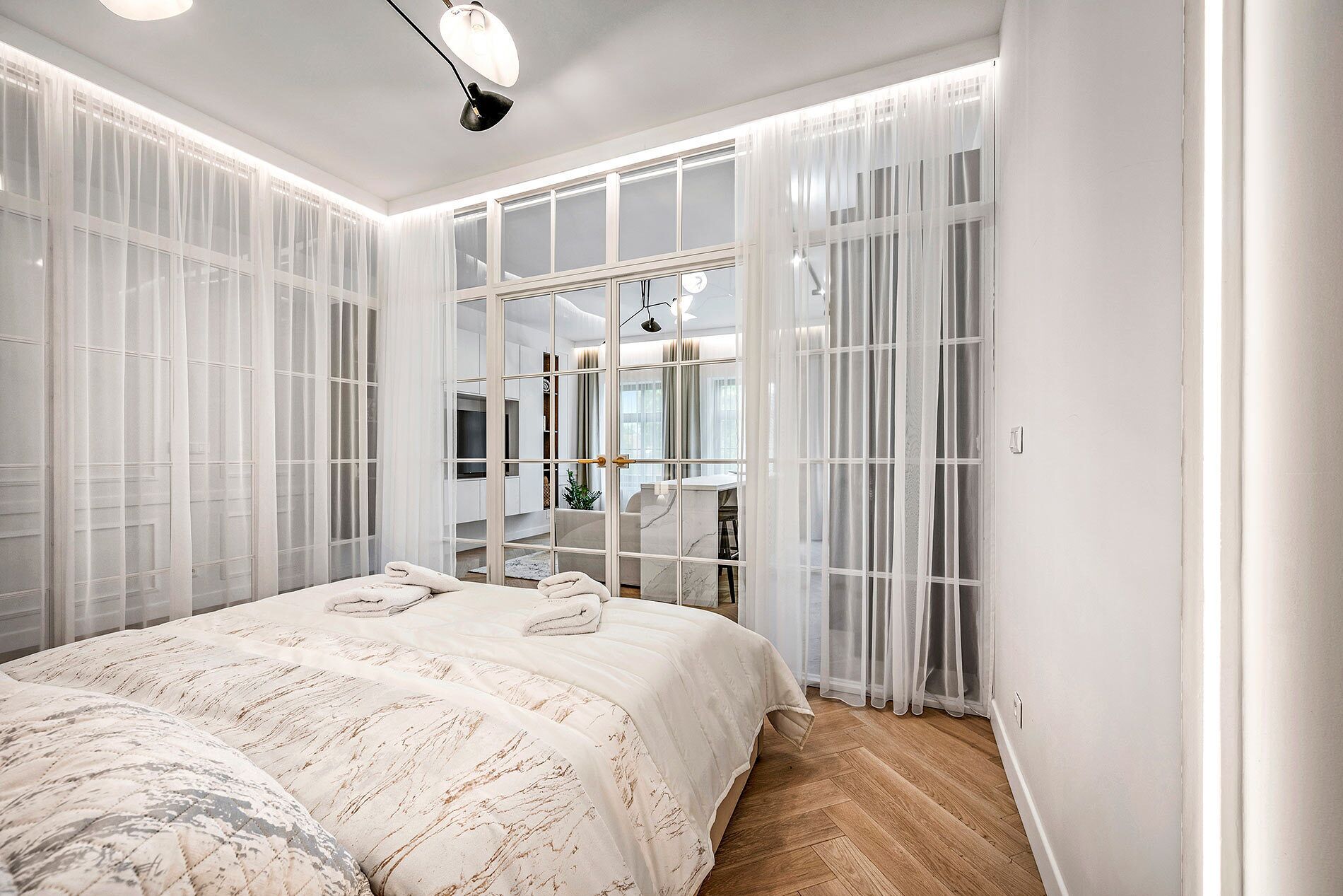 A bedroom with a large bed, a walk-in closet, and a view through the closet doors.