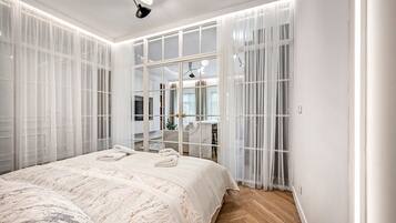 A bedroom with a large bed, a walk-in closet, and a view through the closet doors.