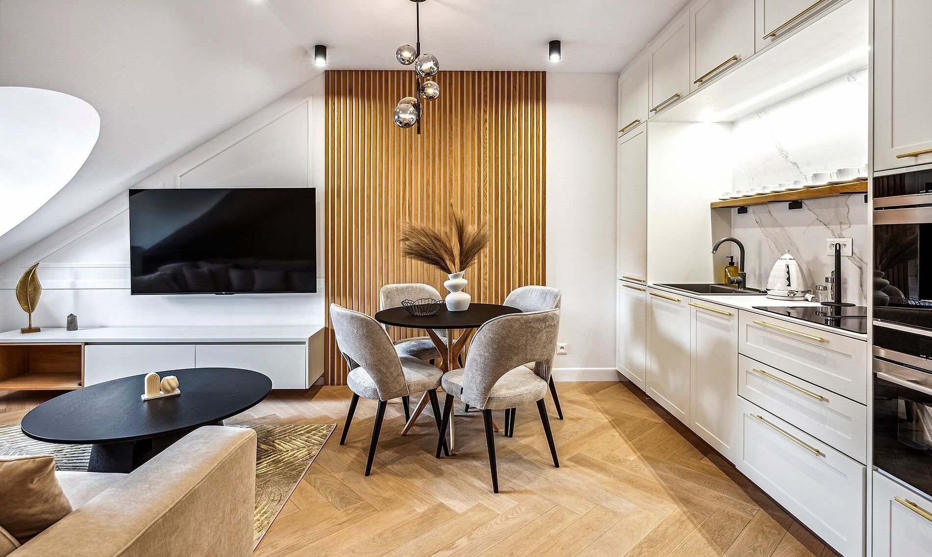 A modern kitchen with white cabinets, a black countertop, and a built-in oven.