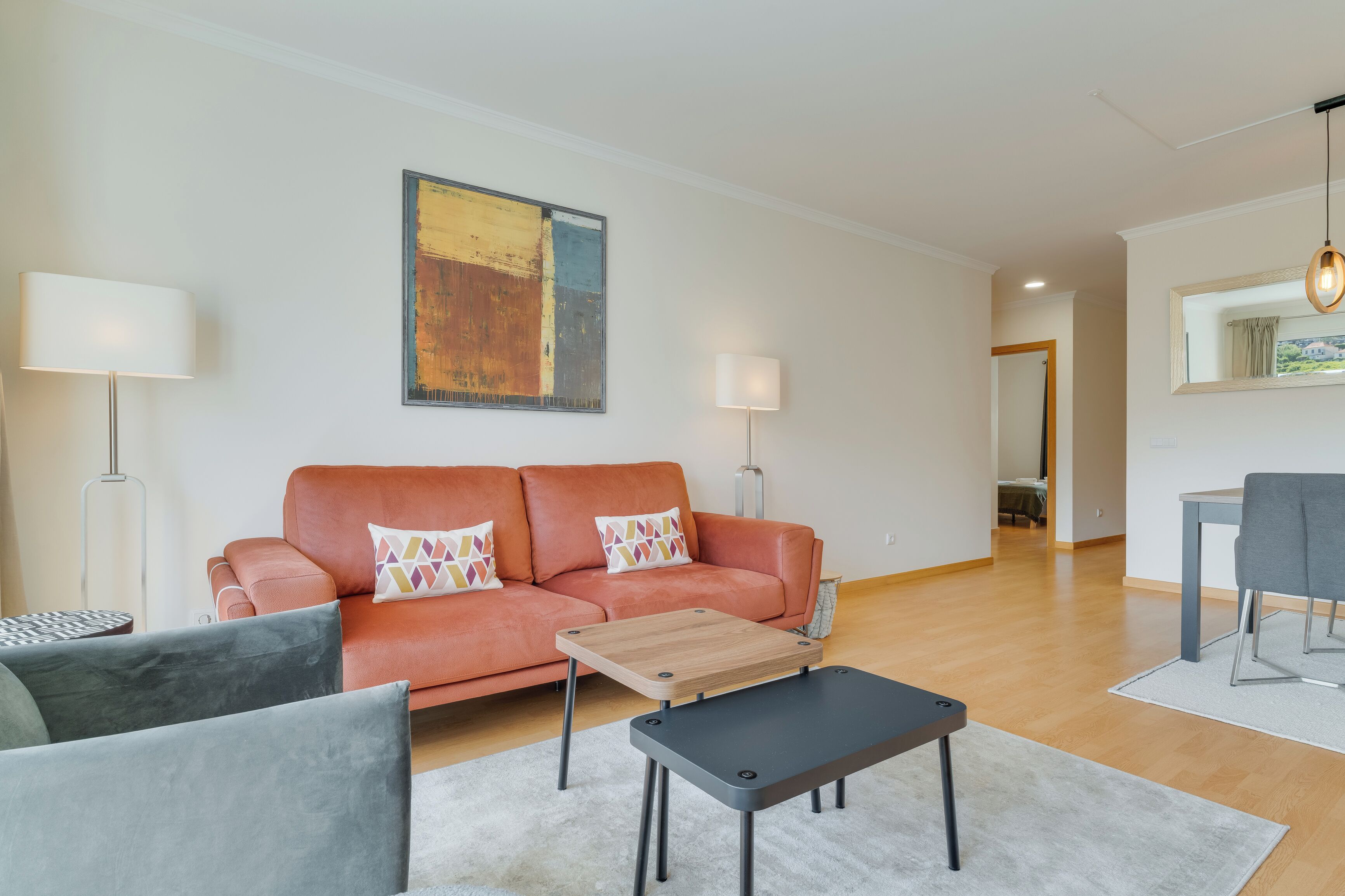 Uma sala de estar moderna com um sofá, uma mesa de centro e uma área de jantar.