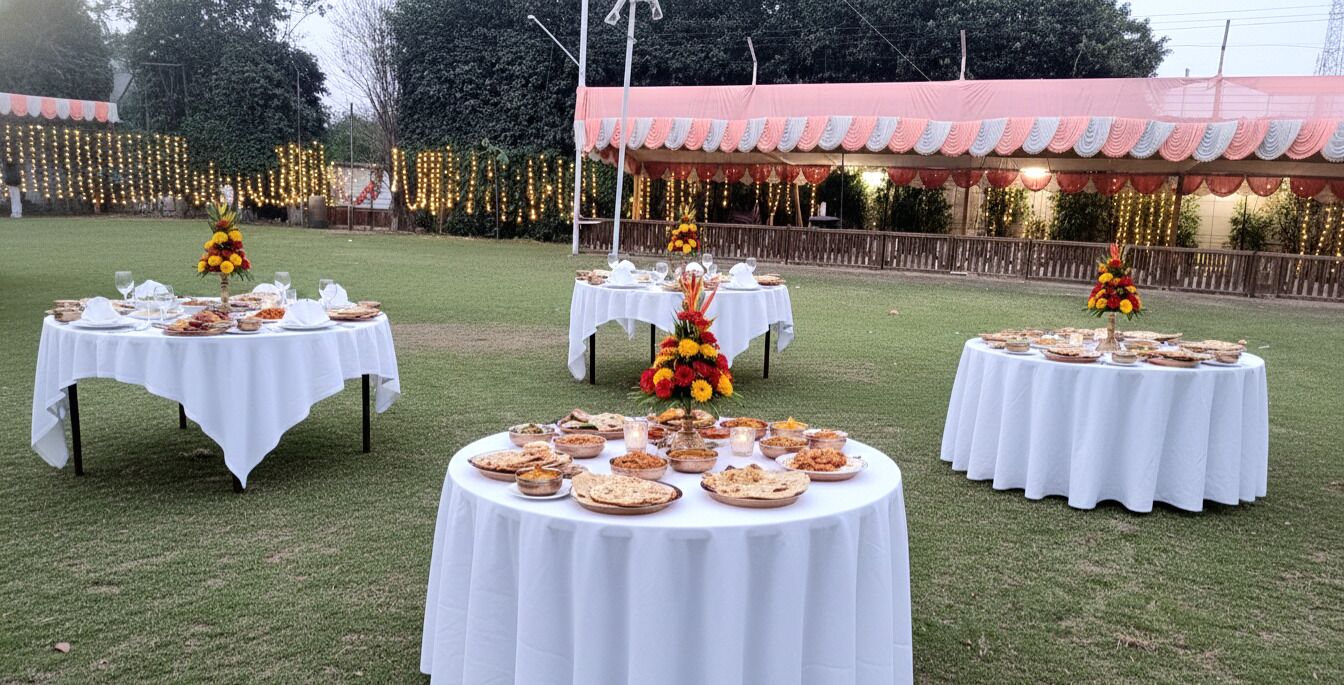 Outdoor round tables with white tablecloths, each surrounded by plates of food and floral centerpieces.
