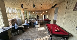 A billiards room with tables, chairs, and a pool table. - Vinayak Palace (Mathura)