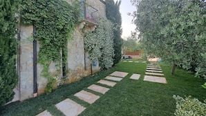 A stone building with a garden path leading to a house. - Villa dell'Olivo Bianco (Castion Veronese)