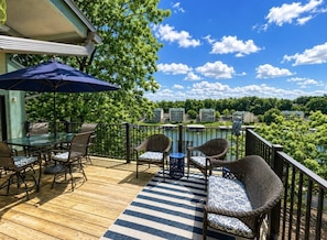A deck with outdoor furniture, a table, and chairs.
