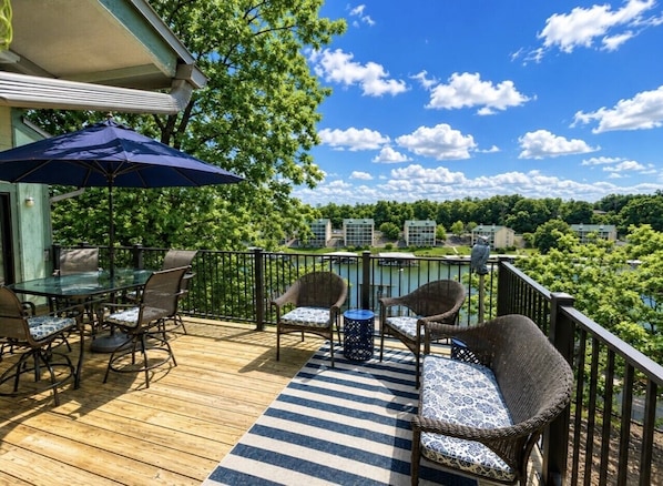 A deck with outdoor furniture, a table, and chairs.