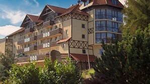 A multi-story hotel with balconies, a central courtyard, and a mix of traditional and modern architectural styles. - Santa Christina (Świeradów-Zdrój)