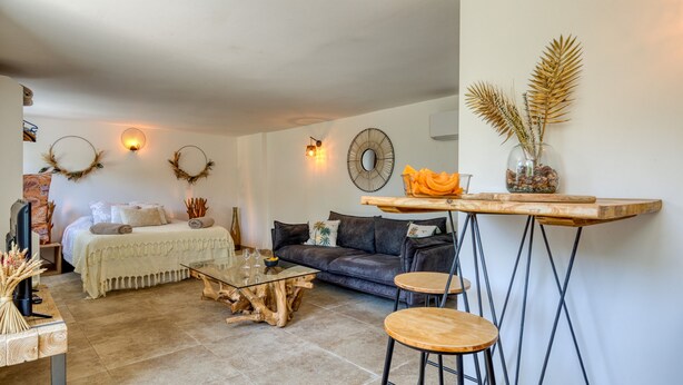 Ein modernes Wohnzimmer mit einem Glastisch, einer Ledersofa und einem Holzbarhocker.