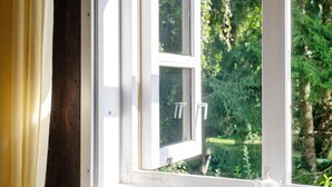 A window with a white frame, a clear view of greenery outside, and a small glass object on the window sill. - A room just for you (Wardow Ortsteil Polchow)