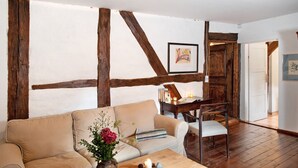 A room with exposed wooden beams, a sofa, a table with candles, and a framed picture on the wall. - Apartment 'Lemon Attic' with Shared Terrace, Shared Garden and Wi-Fi (Wardow Ortsteil Polchow)