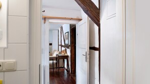 A hallway leading to a room with a wooden ceiling, a white door, and a table with chairs. - Apartment 'Lemon Attic' with Shared Terrace, Shared Garden and Wi-Fi (Wardow Ortsteil Polchow)