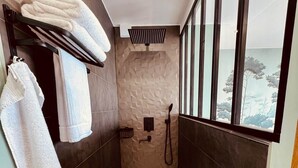 A modern shower room with a built-in bathtub, a towel rack, and a window offering a view of the outdoors. - Evasion room - mia casa (Saint-Mitre-les-Remparts)