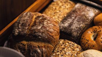 A wooden bread display with various types of bread.