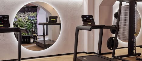 A gym with treadmills, a weight machine, and a mirror.