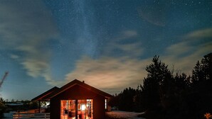 A cabin with a large window, a wooden deck, and a snow-covered ground. - Beautiful home in Ejstrupholm with WiFi (Ejstrupholm)