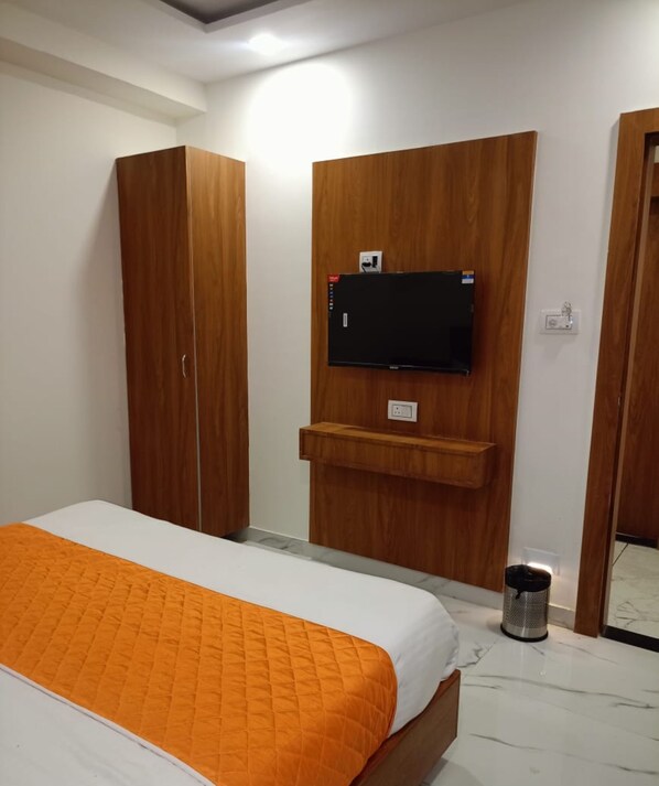 Ein Schlafzimmer mit Bett, Kleiderschrank, Fernseher und Mülleimer.