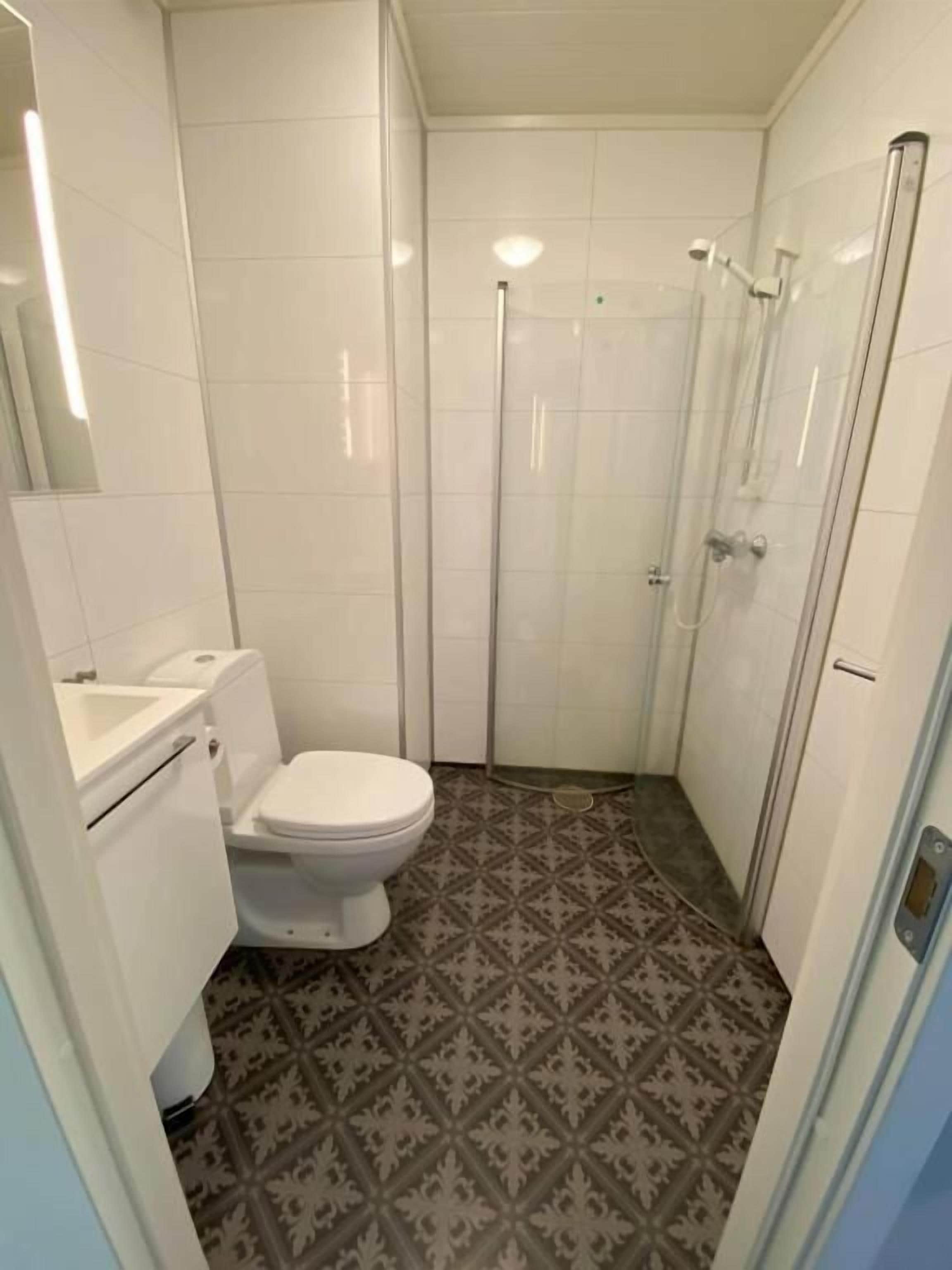 Une petite salle de bain avec des toilettes, une douche et un lavabo.