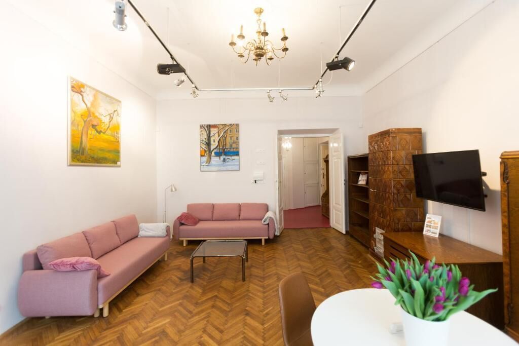 Una sala de estar con dos sofás, una mesa de centro, un televisor y un mueble de madera.