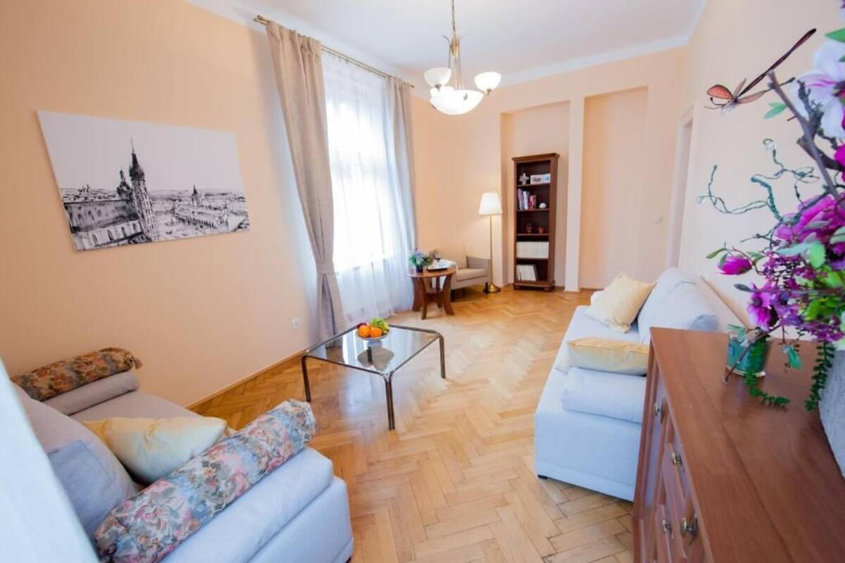 A living room with a sofa, a coffee table, a bookshelf, and a painting on the wall.