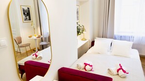 A hotel room with a bed, a desk, a chair, a mirror, and a window with curtains. - Roman Apartments (Kraków)