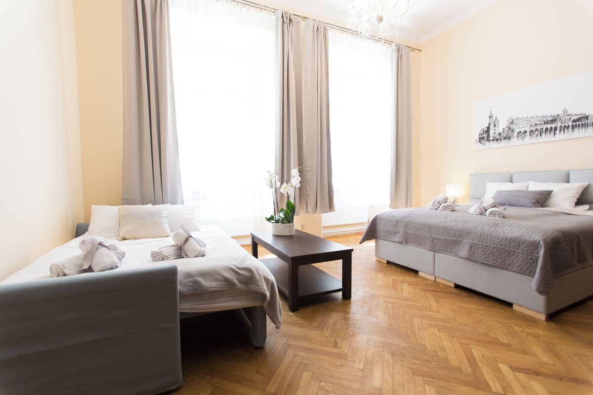 Une chambre d’hôtel avec deux lits, une petite table et une plante en pot.