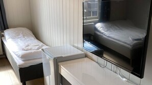 A modern hotel room with a single bed, a desk with a chair, and a TV mounted on the wall. - Finnskoggata 20 (Mosjoen)