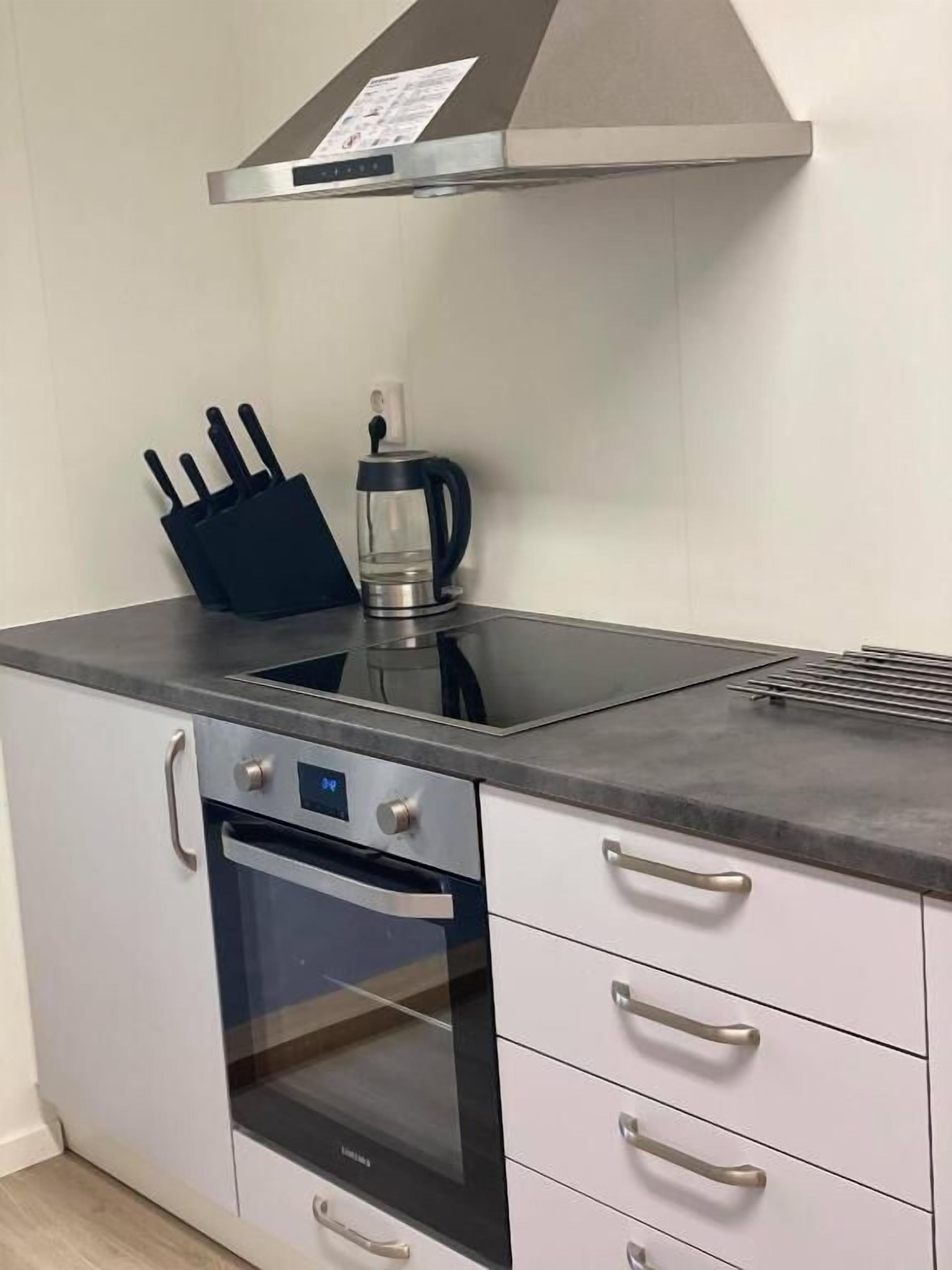 Una cucina con forno in acciaio inossidabile, macchina del caffè e un portacoltelli.