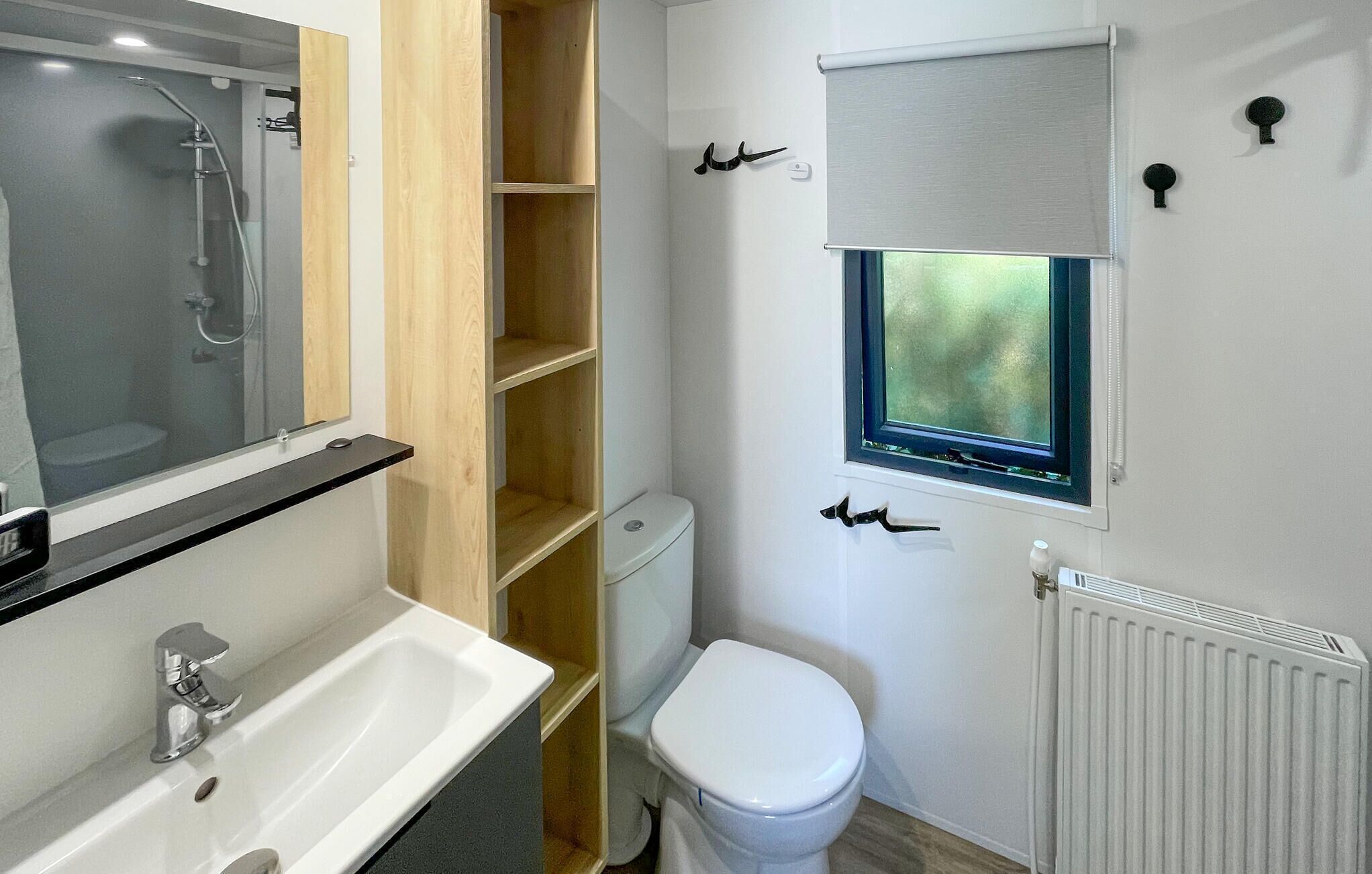Une petite salle de bain comprenant une douche, des toilettes et un lavabo.