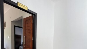 A wooden bench, a potted plant, and a door with a sign reading "POOKODE A2". - VGK RESIDENCY Premium Serviced Apartments (KL)