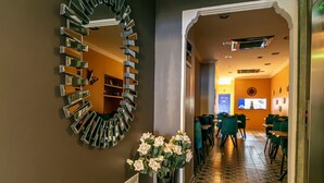 A lobby with a marble floor, a decorative mirror, and a vase of flowers. - Solo Hotel Taksim (İstanbul)
