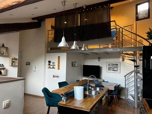 Una cocina moderna con una isla de madera, taburetes de bar e iluminación colgante.