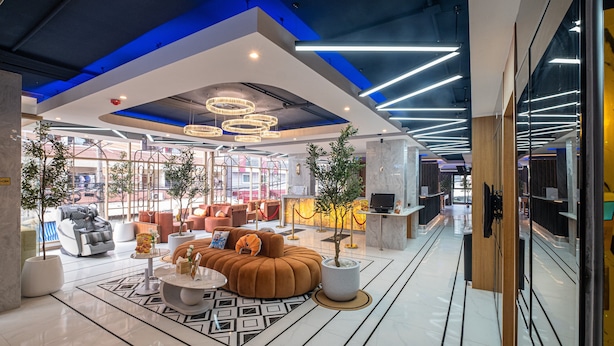 A modern lobby with a seating area, a reception desk, and a large plant. - Metro Hotel Phahonyothin 35 (Bangkok)