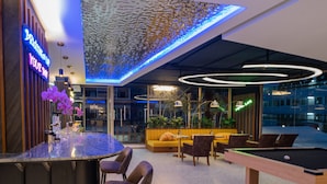 A modern lounge area with a pool table, seating, and a neon sign. - Metro Hotel Phahonyothin 35 (Bangkok)
