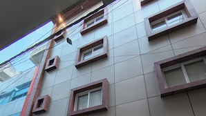A modern building with multiple windows and a large entrance. - Hotel Aman Suites at IGI by Arch Group (New Delhi)