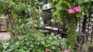 A garden with a bench, a table, and two horse statues.