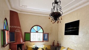 A living room with a sofa set, a coffee table, a fireplace, and a chandelier. - Welcome to Villa Fatima - Your haven of tranquility (Ghazoua)