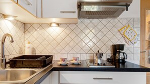 Una cocina con un lavamanos, una cafetera y un tostador.