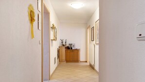 Um corredor com um armário de madeira, um radiador e um interruptor de luz na parede.