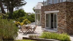 A stone building with a patio area featuring outdoor furniture and a garden. - Meadowside - Rock - stylish retreat sleeping up to 8 guests in 4 bedrooms (Rock)