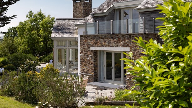 A modern house with a stone facade, large sliding glass doors, and a well-maintained garden. - Meadowside - Rock - stylish retreat sleeping up to 8 guests in 4 bedrooms (Rock)