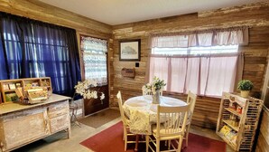 Un coin repas rustique avec une table ronde, des chaises en bois et un buffet de style ancien.