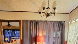 Un salon chaleureux avec deux fauteuils à motifs, une lampe rouge et un tapis à motifs.