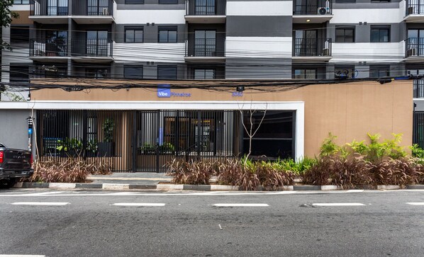 Un bâtiment moderne avec une enseigne indiquant « Vibe Pinheiros » et le numéro « 3060 » sur la façade.