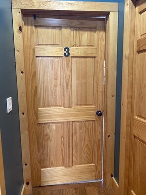 A wooden door with a number '3' above it, a handle, and a keyhole.