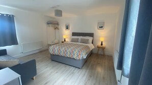Une chambre à coucher avec un lit, des lampes de chevet, une armoire et un radiateur.