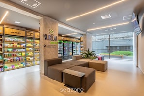 A modern interior with seating areas, snack shelves, and refrigerated beverage displays.