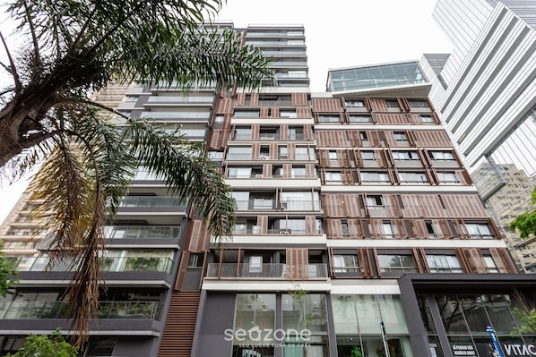 A multi-story building with a modern architectural design, featuring balconies and large windows.