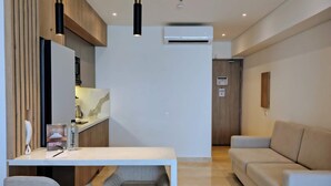A modern hotel room with a white desk, two grey chairs, a beige sofa, and a wooden panel wall. - w Luxurious Loft w Balcony in Crespo (Cartagena)