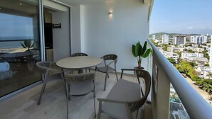 A balcony with a table and chairs, a potted plant, and a city view. - w Luxurious Loft w Balcony in Crespo (Cartagena)